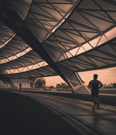 silhouette of a person running along a track