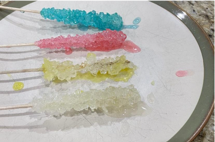 photo of turquoise, pink, yellow, and white crystalline rock candy on sticks